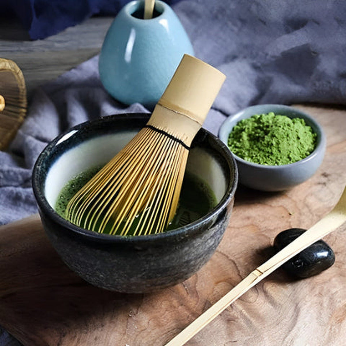 Chasen Bambumie en bambou naturel dans un bol de matcha, poudre de matcha et cuillère en bambou à côté