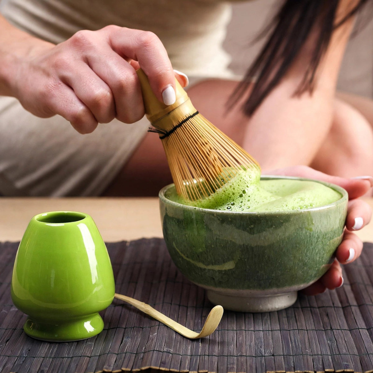 Chasen Bambumie fouettant un matcha à la mousse fine et verte dans un bol en céramique
