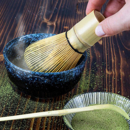 Chasen Bambumie rincé à l'eau chaude au-dessus d'un bol, vapeur et poudre de matcha