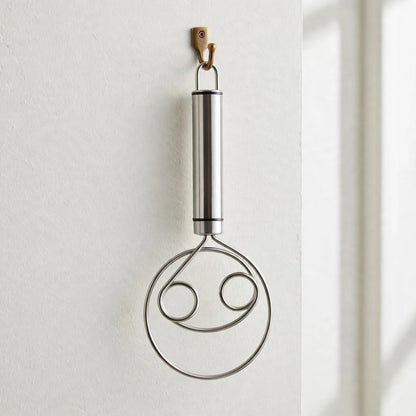 Fouet Cristal suspendu par son anneau à un crochet mural, manche tube en inox