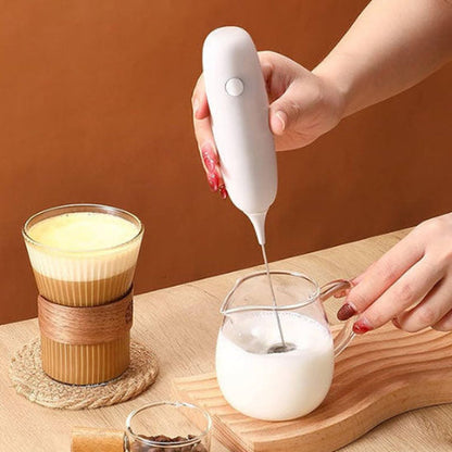 Mousseur électrique Mousso blanc fouettant du lait dans un pichet en verre, geste à une main