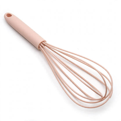 Fouet FlexiPro rose en silicone sur fond blanc, fils plats gainés et manche à trou de suspension