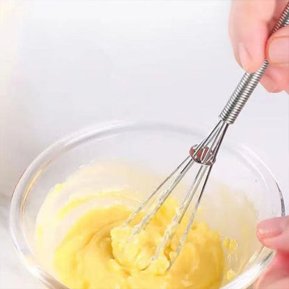 Fouet Fusion en inox battant une crème épaisse dans un bol en verre