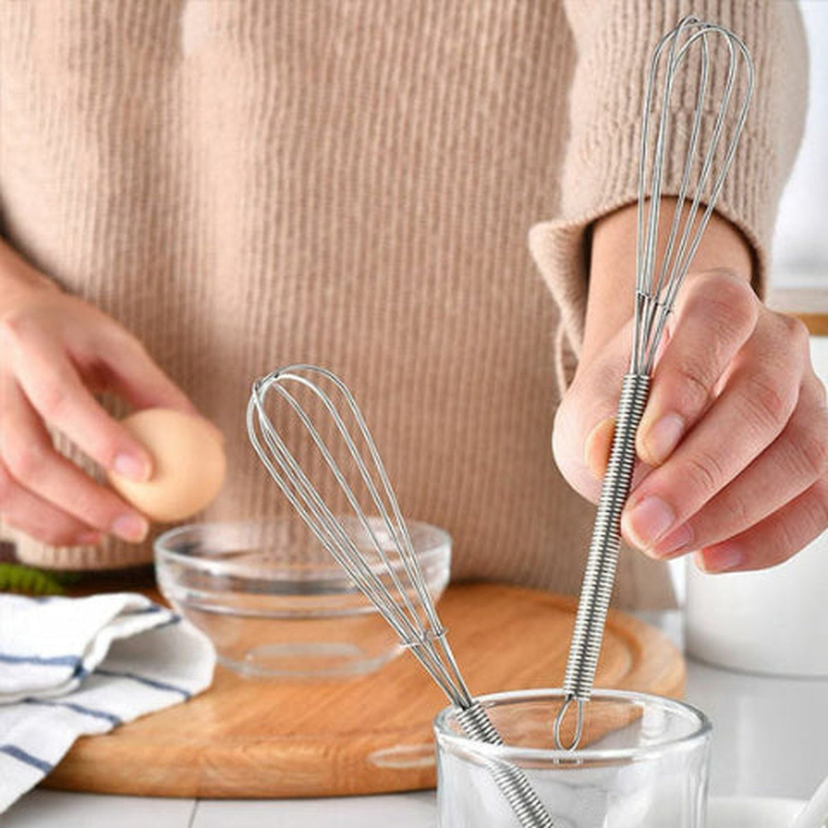 Deux fouets Fusion en inox, dont un plongé dans un verre, plan de travail de cuisine