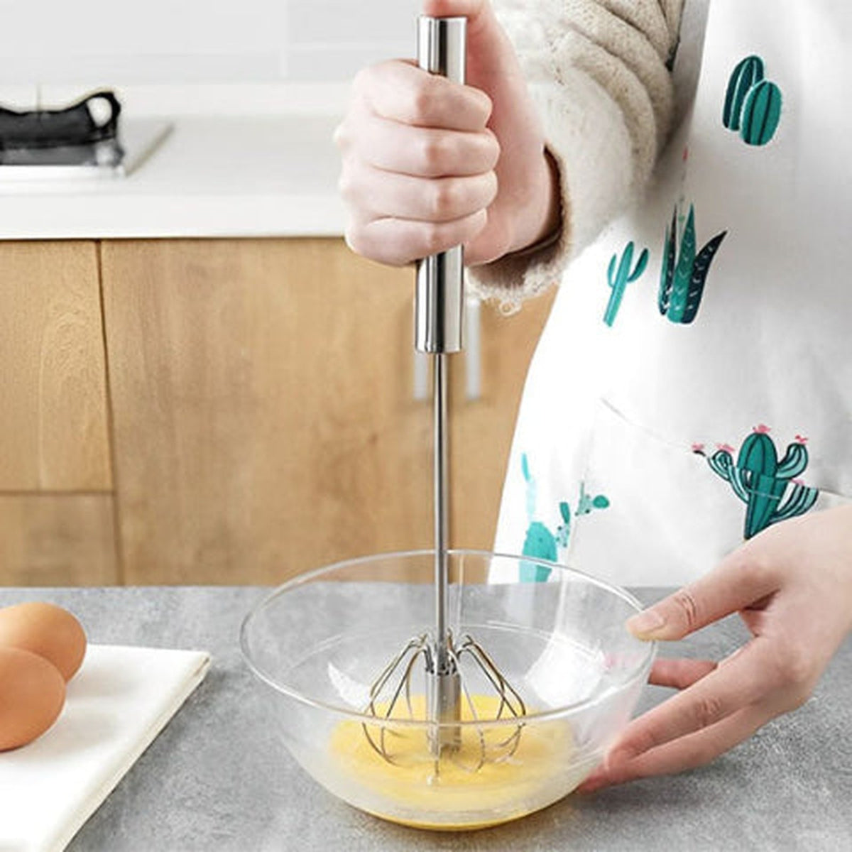 Fouet Mixtourne en action dans une cuisine du quotidien, tablier à motifs cactus
