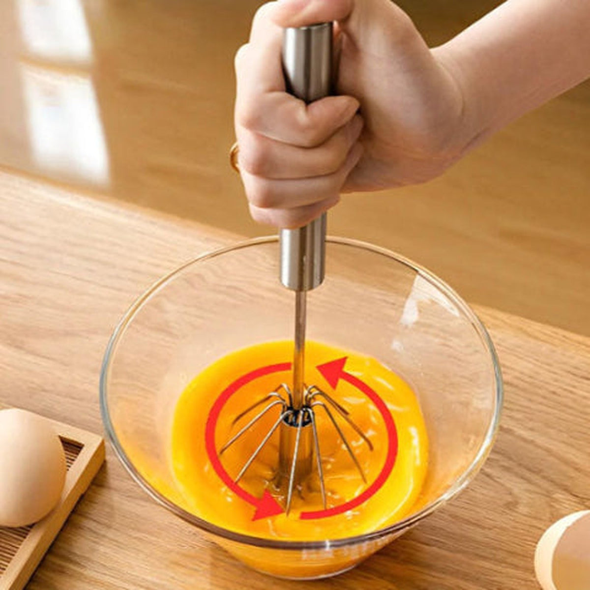Fouet Mixtourne en rotation dans des œufs battus, flèches montrant le double sens de rotation