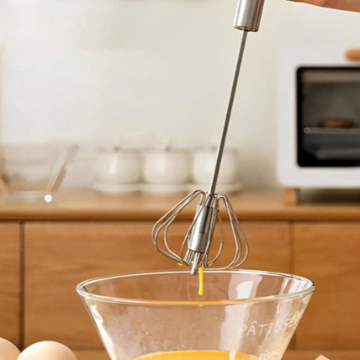 Fouet Mixtourne soulevé au-dessus d'un grand bol en verre, tête ballon en inox
