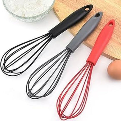 Les trois fouets MixMaster en silicone posés côte à côte : noir, gris et rouge