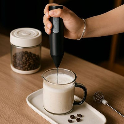 Mousseur à lait AeroMix noir en action dans un pichet de lait posé sur un plateau