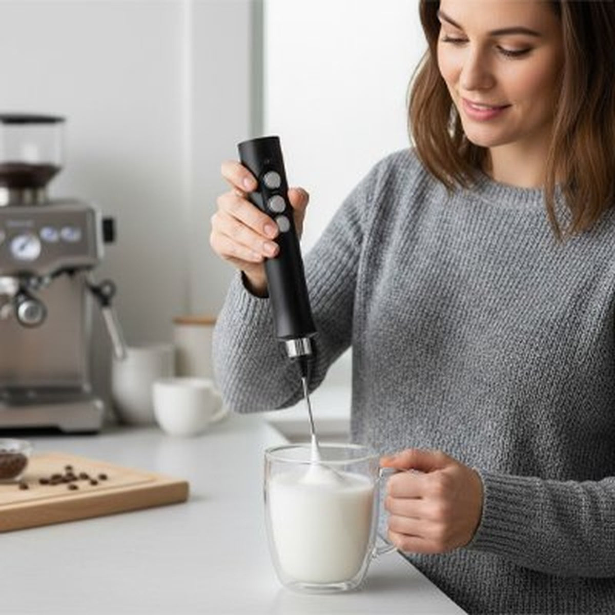 Femme utilisant le mousseur à lait VORTEX EXPRESS dans une tasse de lait, mousse en train de monter