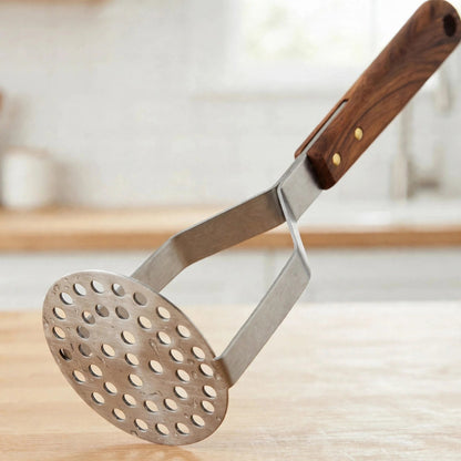Détail de la plaque ronde perforée en inox et de la jonction manche en bois à rivets du presse-purée